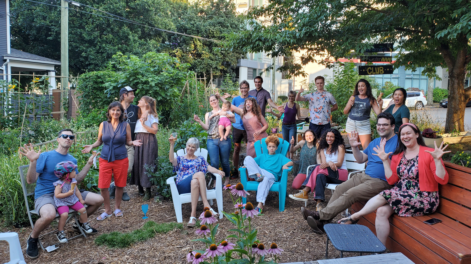 An image of twenty garden stewards gathered outdoors on a summer day