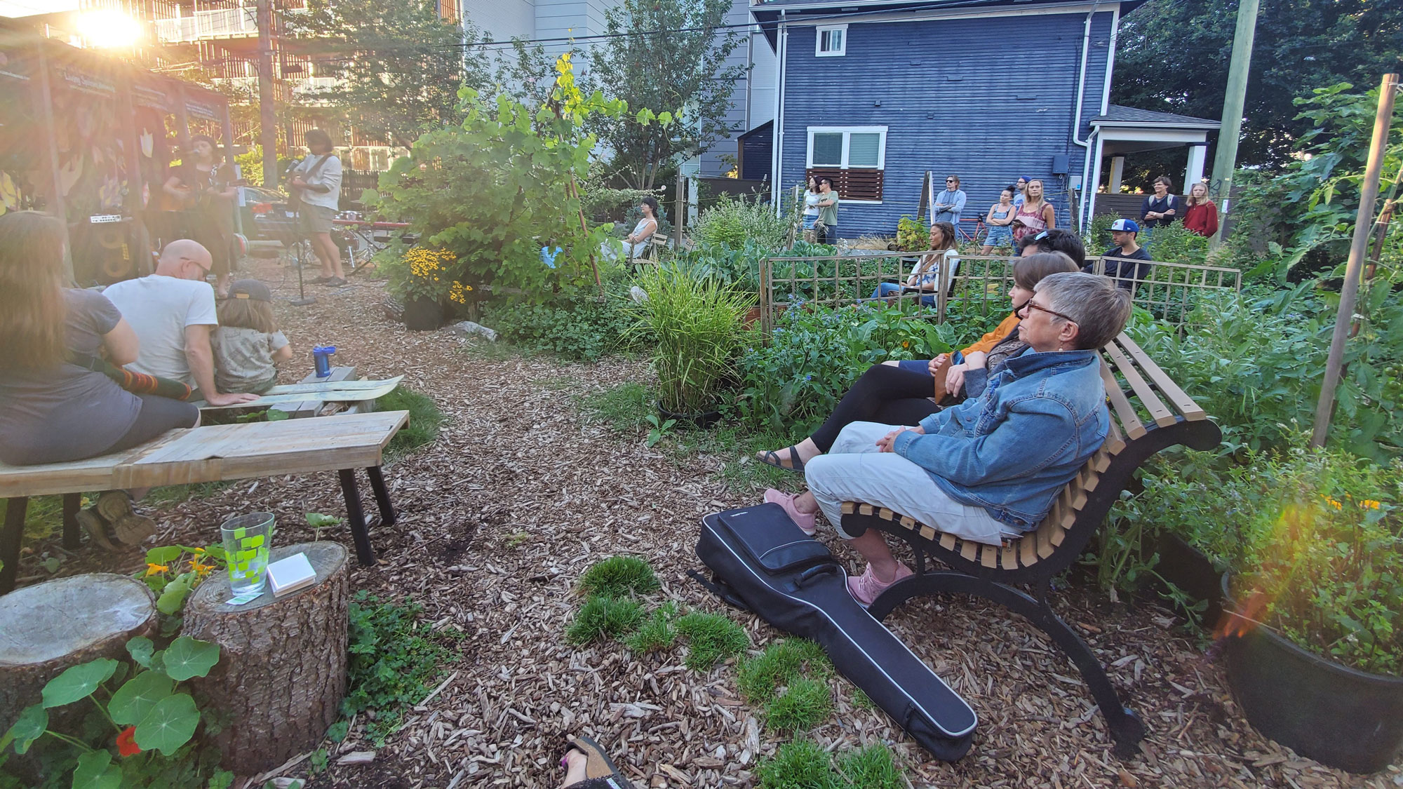 An image of neighbours enjoying music in the garden, at a safe distance from one another during COVID-19